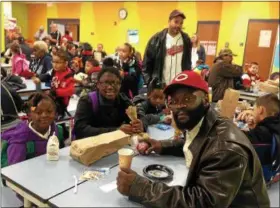  ?? CAROL HARPER — THE MORNING JOURNAL ?? Martin Noble, 40, Lorain, front right, said he enjoyed Donuts with Dads with three of his children: Iyana, 5, kindergart­en, left; Mariana, 9, fourth-grade, middle; and Kiana, 7, second-grade, right Oct. 26, at Helen Steiner Rice Elementary School, 4500...