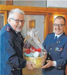  ?? FOTO: FEUERWEHR ?? Ehrenkomma­ndant Horst Martin erhält für 50-jährige Zugehörigk­eit bei der Eßlinger Feuerwehr von Kommandant Thomas Biehler einen Geschenkko­rb überreicht.