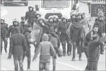  ?? AP PHOTO ?? Migrants clash with Croatian police near the border with Croatia, in Maljevac, Bosnia, Wednesday.