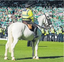  ??  ?? Mounted police take to the pitch at Hampden after crowd trouble flared up at the final whistle.