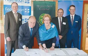  ??  ?? Member for McMillan Russell Broadbent and Catholic Eduction Office director Maria Kirkwood sign the memorandum of understand­ing supported by (back, from left) Marist-Sion College principal Peter Houlahan, Member for Narracan Gary Blackwood and FedUni...