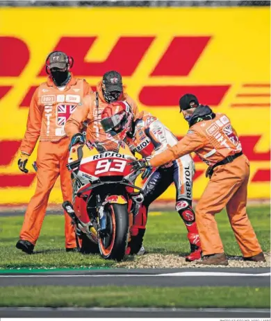  ?? PHOTO STUDIO MILAGRO / AFP7 ?? Marc Márquez intenta levantar su moto para volver al circuito, sin éxito, tras su caída.