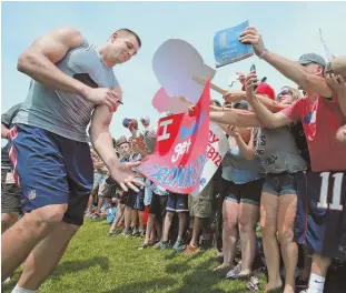  ?? STAFF PHOTOS BY MATT WEST ?? FAN FRENZY: Tight end Rob Gronkowski (above) drew plenty of attention during yesterday’s training camp session in Foxboro. Meanwhile, Malcolm Butler found a quiet moment with his son Malcolm Jr.