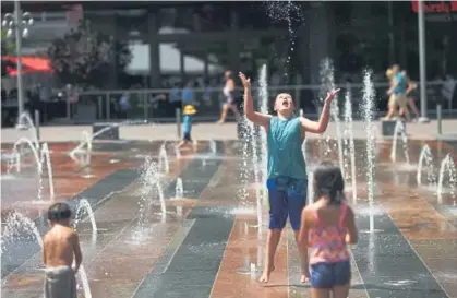  ?? RJ Sangosti, The Denver Post ?? Children cool off in water fountains outside Union Station in Denver on Thursday. The temperatur­e in the Mile High City topped out at 98 degrees. Denver surpassed 90 degrees for the 35th day this year.