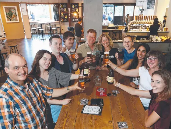  ?? Picture: GLENN HAMPSON ?? Burleigh Brewing owners Brennan and Peta Fielding (centre at head of table) share a toast with thirsty customers yesterday.