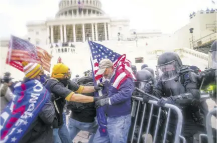  ??  ?? In this January 6, 2021 file photo rioters try to break through a police barrier at the Capitol in Washington.