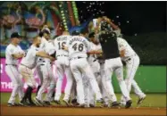  ?? WILFREDO LEE — THE ASSOCIATED PRESS FILE ?? In this file photo, Miami Marlins’ Starlin Castro is mobbed by teammates after he hit a walk-off single in the 12th inning of a baseball game against the Milwaukee Brewers, in Miami. The Marlins won 5-4. Just look at the standings: Thanks to a recent surge, the young Marlins (41-57) are not even last in the NL East. And opponents rave.