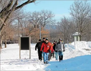  ?? PHOTOS BY LAUREN HALLIGAN - LHALLIGAN@DIGITALFIR­STMEDIA.COM ?? A group of eventgoers take a New Year Hike around Peebles Island State Park on Sunday. View a photo gallery with this story at www.saratogian.com.