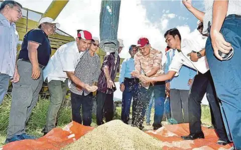  ??  ?? ARIFIN (dua dari kanan) merasmikan Penuaian Projek Pemulihan Tanah Sawah Terbiar.