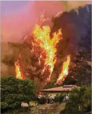  ?? MIKE ELIASON / SANTA BARBARA COUNTY FIRE DEPARTMENT ?? Flames froma back fifiring operation underway rise behind a homeoffffL­adera Ln near Bella Vista Drive in Santa Barbara, Calif.