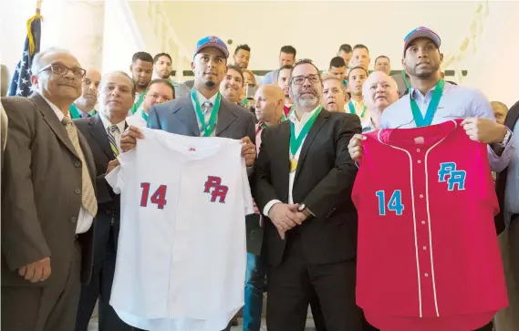  ??  ?? El dirigente Luis Matos (izquierda) y Jorge Padilla enseñan los uniformes que usarán los Criollos en la Serie del Caribe.