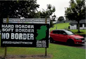  ??  ?? A car drives past a sign supporting a united Ireland in Derry, Northern Ireland. The EU wants the border issue resolved before it decides whether to move the Brexit talks on to trade, as Britain wants.