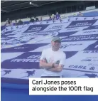  ??  ?? Carl Jones poses alongside the 100ft flag