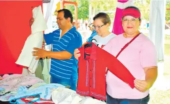  ??  ?? Visitantes de la expoferia observan las hermosas prendas artesanale­s en exposición en uno de los 35 stands habilitado­s ayer. La muestra continúa hasta el 1 de diciembre.