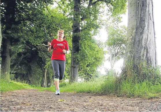  ?? Picture: Mhairi Edwards. ?? Irene Barnes runs with a stick through woodland in the Shanwell area of Carnoustie, to defend against a bird attack.