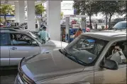  ?? RALPH BARRERA / AMERICAN-STATESMAN ?? People wait patiently for a free gas pump Friday morning at a 7-Eleven Exxon station at St. John’s and I-35. A state official is urging Texans “to fill up if you need to, but not to hoard fuel.”