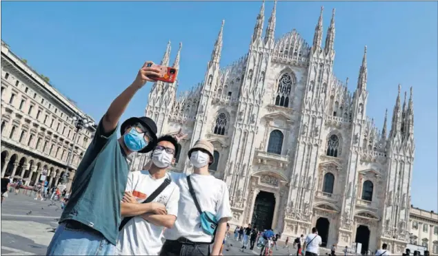  ??  ?? Milán vuelve a sonreír después de haber sido una de las zonas que inicialmen­te se vieron más afectadas en la pandemia. En la imagen, unos turistas ayer frente al Duomo.