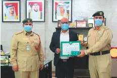  ??  ?? Brigadier Yousuf Abdullah Salim Al Adidi honours Retesh James Gupta with a certificat­e at Al Ghusais Police Station.