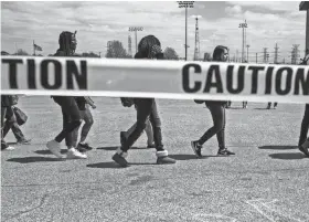  ?? BRAD ?? Cordova High School students walk past chalk outlines representi­ng the victims of the mass shooting at Marjory Stoneman Douglas High School in Parkland, Florida, during a student walkout at Cordova High School . VEST/THE COMMERCIAL APPEAL