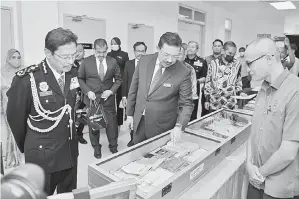  ?? — Gambar Bernama ?? LAWATAN: Ketua Setiausaha Negara, Tan Sri Mohd Zuki Ali (tengah) melawat ruang pameran mengenai bahan penerbitan yang menyalahi undang-undang pada majlis perasmian Kompleks Suruhanjay­a Pencegahan Rasuah Malaysia (SPRM) Terengganu di Bukit Besar, Kuala Terengganu semalam. Turut hadir Azam Baki (kiri). Kompleks SPRM yang dibina di atas tanah seluas 3.41 hektar mula beroperasi pada 15 Julai 2019 dengan kos RM38 juta. Kompleks yang mempunyai tiga blok turut dilengkapi dengan kemudahan bilik rakaman percakapan saksi, bilik video interviewi­ng room (VIR), lokap, bilik gerakan operasi (BGOS), dewan seminar, gudang sita dan bilik kawad cam.