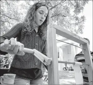  ?? Arkansas Democrat-Gazette/MITCHELL PE MASILUN ?? Abigail Evans, 12, of Cabot tries her hand at rolling bandages Saturday during the World War I centennial commemorat­ion event at the Old State House Museum in Little Rock.