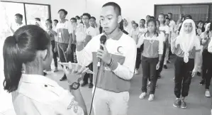  ??  ?? (Gambar atas) MOHD Syafiq Amierul Syazwan Shahrian dari Sekolah Agama Tun Mustapha mengetuai angkat sumpah BSMM. (Gambar kiri) HAJAH NANIH (empat dari kanan) mengisi Tabung Jualan Bendera bersama wakil guru sekolah dan AJK sempena bulan jualan bendera...