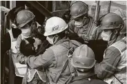  ?? Chen Hao / Associated Press ?? Rescuers carry a man who was trapped in a mine in the eastern Chinese province of Shandong on Sunday.