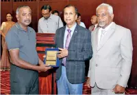  ??  ?? M. Victor Pushpasiri receiving the BMICH Employee of the Year 2019 Award from Sunil Dissanayak­e - Director/Chief Executive, BMICH