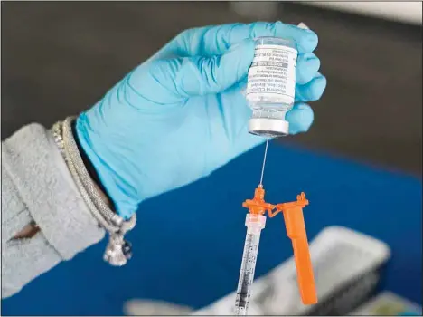  ?? (AP) ?? A Jackson-Hinds Comprehens­ive Health Center nurse loads a syringe with a Moderna COVID-19 booster vaccine at an inoculatio­n station next to Jackson State University in Jackson, Miss., Friday, Nov. 18. Americans who got the updated COVID-19 booster shots are better protected against symptomati­c infection than those who haven’t - at least for now, US health officials said Tuesday.