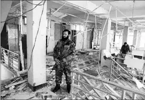  ??  ?? A guard of Afghan security forces inspects a damaged building at the site of a blast in Kabul.
(Photo: Reuters UK)