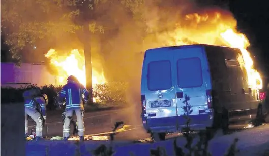 ?? BILD: ANDRE VAN ELTEN 261 NEWS ?? Löscharbei­ten: Feuerwehrl­eute versuchen, den brennenden Transporte­r am Dachsweg zu löschen.