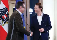  ?? (Leonhard Foeger/Vienna) ?? FREEDOM PARTY head Heinz-Christian Strache (left) shakes hands with People’s Party chief Sebastian Kurz at the end of a news conference in Vienna on Friday.