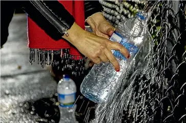  ??  ?? Some Christchur­ch residents have taken to filling containers with spring water instead of drinking the city’s chlorinate­d tap water.