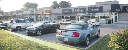  ?? JEAN LEVAC ?? Police cordoned off the parking lot of a strip mall on Iris Street where a shooting occurred Monday night. The victim of the shooting later died of his injuries.