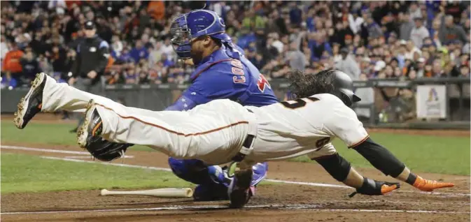  ??  ?? SAN FRANCISCO: San Francisco Giants’ Brandon Crawford, bottom, scores past Chicago Cubs catcher Willson Contreras during the fourth inning of a baseball game in San Francisco, Tuesday. — AP