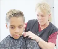  ?? FILE PHOTO ?? Missy Trentham gives a free haircut during the 2019 Back 2 School Bonanza in Lincoln. This year, Lincoln will have a drive-through service to hand out free tennis shoes and backpacks for children to start the new school year. The registrati­on form includes a question for those who are interested in receiving a voucher for a free haircut.