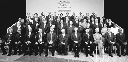  ?? — Reuters photo ?? G-20 finance ministers and central bank governors pose for a family photo before a plenary session during the IMF/World Bank annual meetings in Washington, US, October 12. Finance chiefs from around the world were warned to get their houses in order...