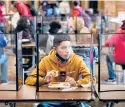 ?? RIEDEL/AP
CHARLIE ?? Hugo Bautista, a high school freshman, eats lunch Wednesday, the first day of in-person learning, separated from classmates by dividers in Kansas City, Kansas.