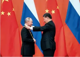  ??  ?? Xi Jinping remet à Vladimir Poutine la première médaille de l’Amitié de la République populaire de Chine.