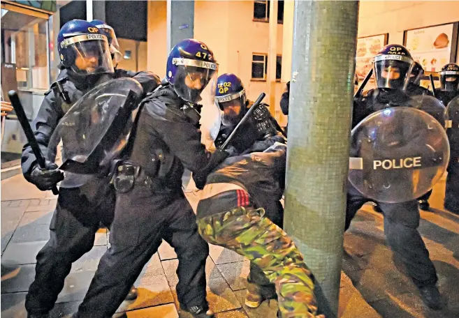  ??  ?? Police officers in riot gear detain a man as they move in on demonstrat­ors in Bristol during the ‘Kill the Bill’ protest against the Police, Crime, Sentencing and Courts Bill on Friday night