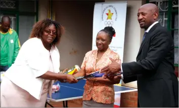  ??  ?? INVESTING IN THE FUTURE . . . Zimbabwe Olympic Committee president Admire Masenda (far right) hands over part of the equipment they distribute­d yesterday to Warren Park 5 Primary School deputy headmistre­ss Rosemary Dzvairo (left), while ZOC...