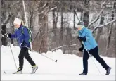  ?? Joseph Prezioso / Getty Images ?? Why not do as these women are, in Weston, Mass., and break out some crosscount­ry skis this snowy winter?