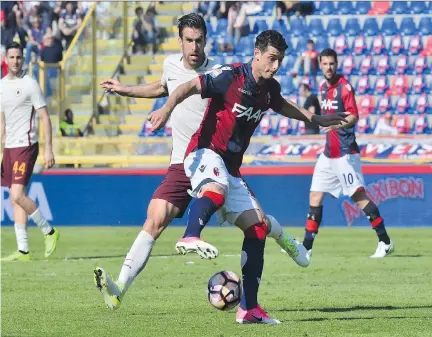  ?? GIUSEPPE CACACE/AFP/GETTY IMAGES ?? Bologna’s Blerim Dzemaili, front, battles Roma’s Kevin Strootman during an Italian Serie A match last month.