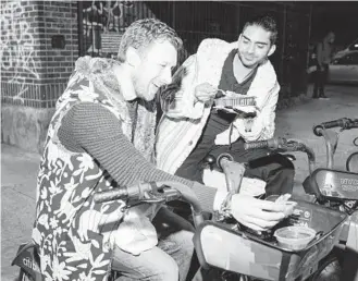  ?? LANNA APISUKH/THE NEW YORK TIMES PHOTOS ?? A Citi Bike doubles as a table as Neal Bakshi, right, and his friend Oliver Griffiths enjoy fajitas from a taco truck on April 23 in New York.