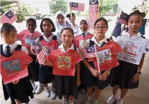  ??  ?? Pupils of SJKC Ave Maria Convent displaying the T-shirt templates that they designed for The Star Media Group #Raise the flagMY campaign during a special assembly.