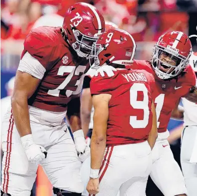  ?? KEVIN C. COX/GETTY ?? Alabama’s Bryce Young celebrates a touchdown with Evan Neal (73) in the SEC Championsh­ip on Saturday.