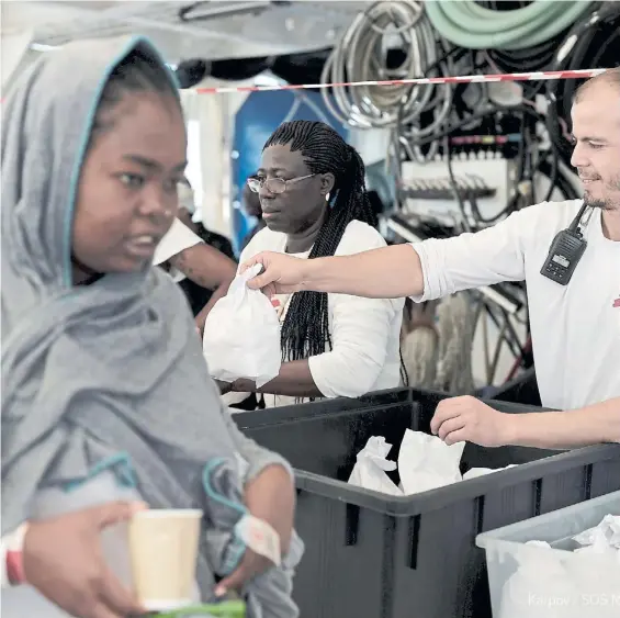  ?? DPA ?? Llegada. Inmigrante­s africanos reciben alimentos a bordo del buque Aquarius, poco antes del arribo al puerto español de Valencia.