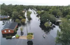  ?? EPA ?? In New Bern, North Carolina, canoeists paddle the streets past homes and businesses under metres of water