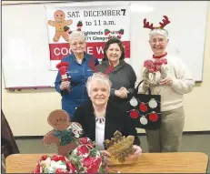  ?? NWA Democrat-Gazette / BECCA MARTIN-BROWN ?? Jean Galloway (seated front), Suzanne Evans, Nancy Johnson and Pat Lehman (standing from left) pause during a Cookie Walk work day to promote the Dec. 7 event. The Cookie Walk is now in its 31st year at Highlands United Methodist Church in Bella Vista.