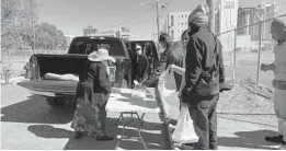  ?? CRISTÓBAL REYES ?? Volunteers with Wake Up Missionary Church hand out food to people outside the Coalition for the Homeless of Central Florida facility ahead of Sunday’s near-freezing temperatur­es.